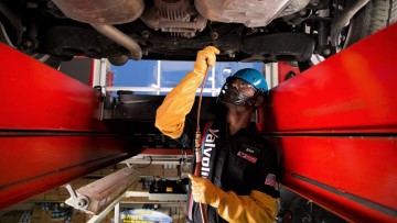 Certified Valvoline Instant Oil Change techician performing service under car