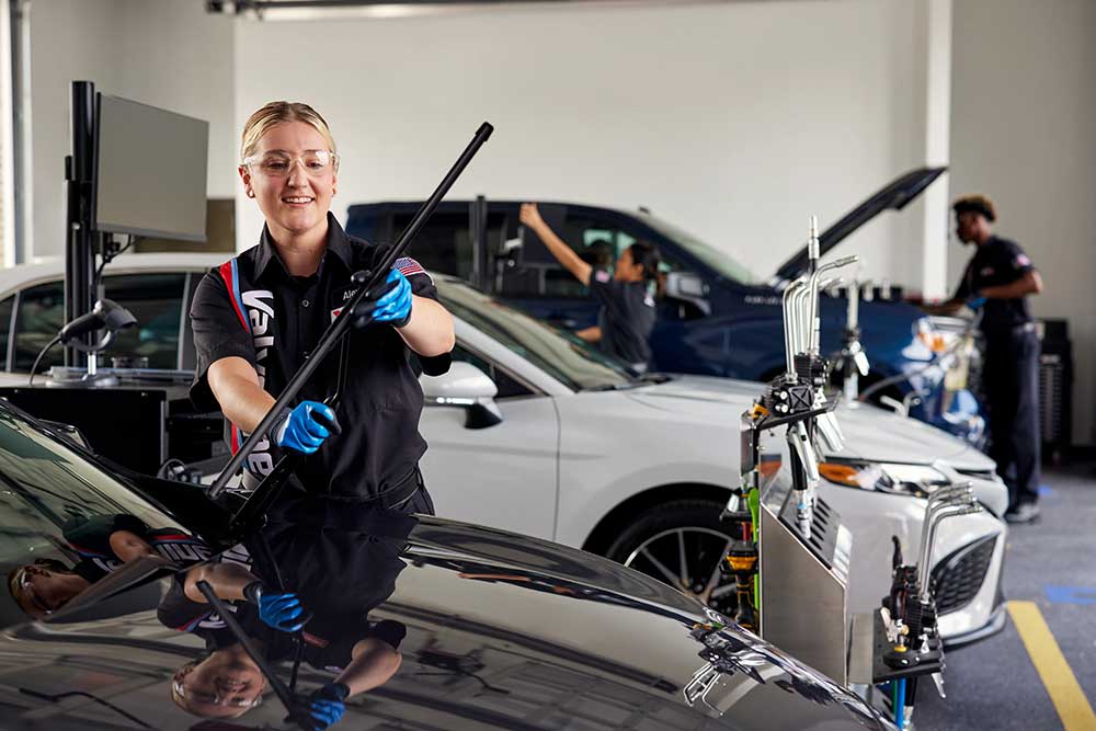 Certified Valvoline Instant Oil Change technician replacing wiper blases on a black vehicle